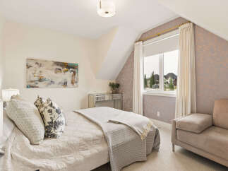 Discover this charming bedroom featuring a comfortable bed adorned with decorative pillows and a cozy throw.