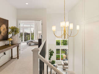Experience luxury living in this stunning home, featuring a grand foyer with a modern chandelier and elegant wainscoting.