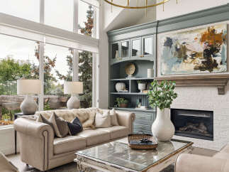 Experience luxury living in this stunning living room, featuring a grand fireplace and a large abstract painting above the mantel.