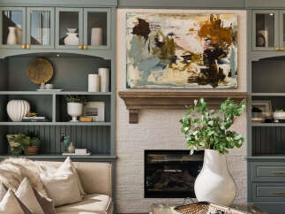 This living room features a stunning built-in bookshelf with glass-front cabinets and open shelving, perfect for displaying decor.