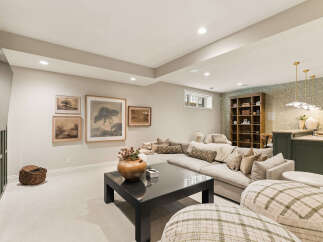 This inviting living room features a spacious sectional sofa perfect for gatherings, complemented by a dark wood coffee table and a decorative vase.