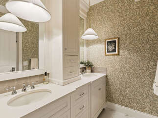 This elegant bathroom features a double vanity with sleek chrome fixtures and a neutral-toned countertop.