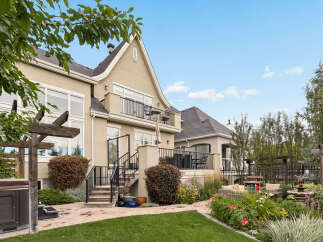 Experience luxurious outdoor living with this stunning backyard featuring a spacious patio, a relaxing hot tub, and a beautifully landscaped garden.