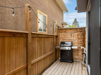Enjoy outdoor living with this charming backyard featuring a wooden deck and a built-in grill station, perfect for summer barbecues.