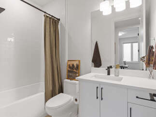 This modern bathroom features a sleek white subway tile shower and a deep soaking tub, perfect for relaxation.