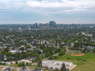 Experience urban living with this stunning aerial view showcasing a vibrant cityscape and a well-maintained residential neighborhood.