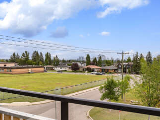 Enjoy this scenic view overlooking a park and distant city skyline, perfect for a peaceful retreat.