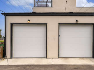 This modern garage features two sleek white sectional garage doors, perfect for a two-car household.
