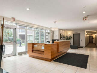 Welcome guests into this inviting lobby featuring a modern reception desk and elegant chandelier.