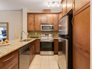 Discover this beautifully appointed kitchen featuring sleek stainless steel appliances, including a microwave and a spacious refrigerator.
