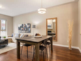 Experience modern urban living in this stylish dining and living area, featuring a spacious sectional sofa perfect for relaxation and a sleek dining table set for intimate meals.