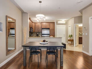 This open-concept living space features a modern dining area with a sleek table and chairs, perfect for intimate meals.