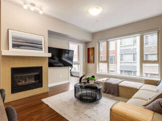 Experience modern living in this stylish apartment featuring a cozy gas fireplace and a large flat-screen TV, perfect for entertaining.