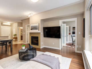 Experience modern living in this beautifully appointed condo, featuring a sleek fireplace and a large flat-screen TV perfect for entertainment.