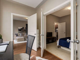 Discover comfortable living in this inviting space, featuring a dedicated home office area with a laptop and a plant, perfect for productivity.