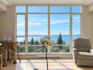 Experience breathtaking panoramic views of the ocean and city skyline from this stunning living room.
