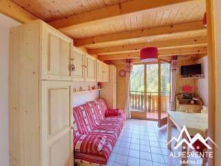This charming mountain retreat features a cozy living area with a red and white striped sofa, perfect for relaxing after a day of outdoor adventures.