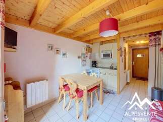 This charming studio apartment features a cozy dining area with a wooden table and chairs, perfect for enjoying meals.