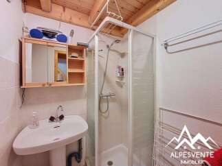 Discover this charming bathroom featuring a corner sink and a modern glass-enclosed shower.