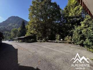 Discover this spacious outdoor parking area, perfect for residents and guests, nestled amidst lush greenery and offering stunning mountain views.