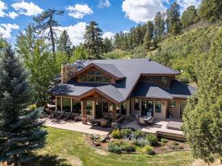 Experience luxurious mountain living in this stunning home, nestled amidst mature trees and rolling hills.