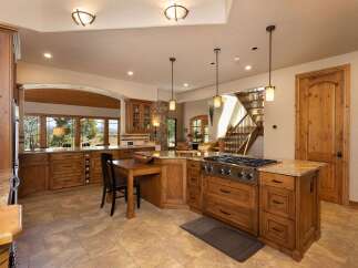 Experience luxury living in this stunning kitchen, featuring custom wood cabinetry, granite countertops, and a professional-grade gas range.