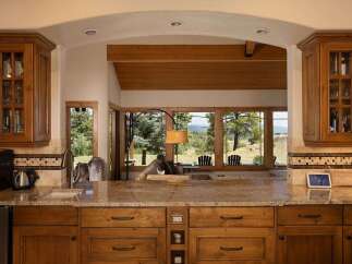 Experience breathtaking mountain views from this stunning kitchen, featuring custom wood cabinetry and granite countertops.
