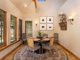 This dining room features a round dark wood table with upholstered chairs, perfect for intimate gatherings.
