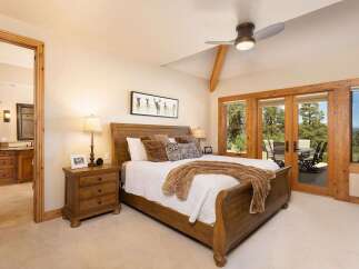 Experience rustic elegance in this charming bedroom featuring a sturdy wooden sleigh bed and a cozy white quilt.