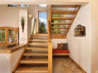 Ascend to the upper level via a beautiful wooden staircase, bathed in natural light from large windows.