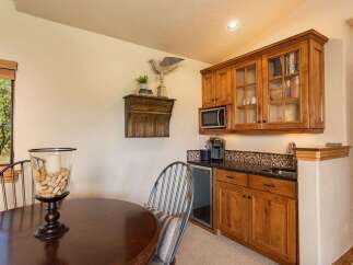 This charming wet bar area features beautiful custom wood cabinetry, a built-in microwave, and a convenient under-counter beverage refrigerator.