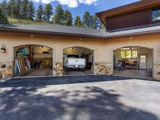 This spacious garage offers ample storage and parking for multiple vehicles, including a large pickup truck and motorcycles.