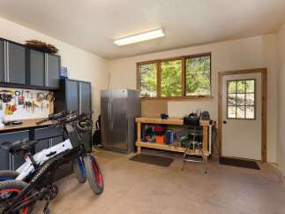 This spacious garage offers ample storage with sleek grey cabinets and a convenient pegboard for organizing tools.