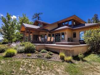 Experience luxurious outdoor living with this expansive deck, featuring a relaxing hot tub and a dining area perfect for entertaining.