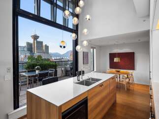 Experience luxury urban living with this stunning penthouse featuring breathtaking city and mountain views through expansive floor-to-ceiling windows.