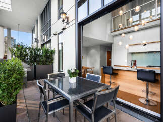 Enjoy outdoor living on this spacious balcony, perfect for al fresco dining with a sleek table and chairs.