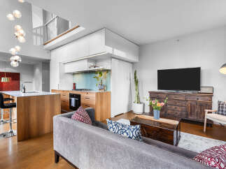 Experience modern living in this stunning open-concept space, featuring a sleek kitchen with a waterfall island and a spacious living area perfect for entertaining.