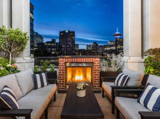Experience luxurious urban living with this stunning rooftop patio, featuring a cozy fireplace and breathtaking city skyline views.