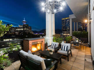 Experience luxurious urban living on this stunning rooftop patio, complete with a cozy fireplace and breathtaking city views.