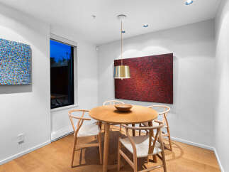 This dining area features a round wooden table with four modern chairs, perfect for intimate meals.