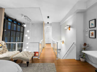 Experience modern loft living with this stunning interior featuring a spacious open-concept layout and a dramatic multi-level chandelier.