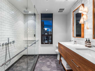 Experience modern luxury in this stunning bathroom featuring a spacious walk-in shower with sleek subway tile and chrome fixtures.