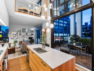 Experience modern urban living in this stunning loft-style condo featuring an open-concept living space with a gourmet kitchen island and a spacious balcony overlooking the city skyline.