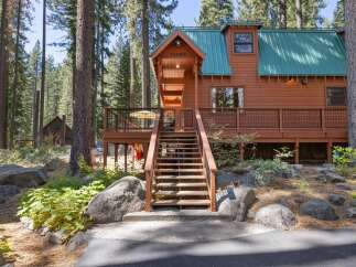Nestled amongst towering pine trees, this charming cabin offers a serene mountain retreat.