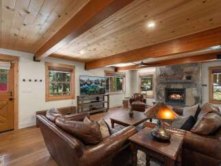 Experience rustic charm in this inviting living room, featuring a grand stone fireplace perfect for cozy evenings.