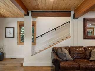 Experience rustic charm with this inviting living space, featuring exposed wooden beams and a warm, natural wood ceiling.