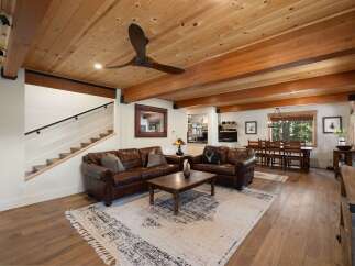 Experience rustic charm in this spacious living and dining area, featuring warm wood ceilings and exposed beams.
