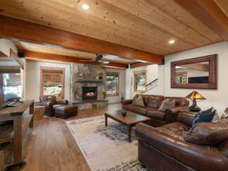 Experience rustic charm in this inviting living room, featuring a grand stone fireplace as the centerpiece.