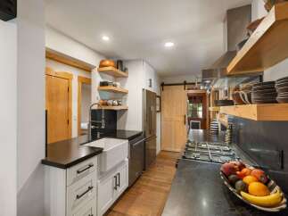 Discover this charming kitchen featuring a farmhouse sink, sleek granite countertops, and a professional-grade gas range.