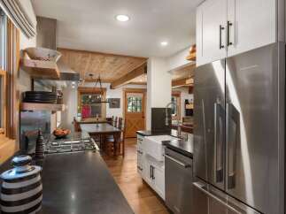 Experience rustic charm in this beautifully appointed kitchen, featuring a sleek stainless steel refrigerator and a gas range perfect for culinary adventures.
